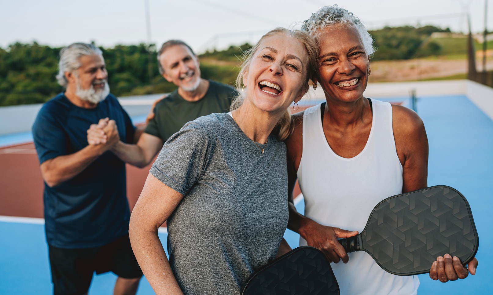 Group of people playing pickleball looking at camera