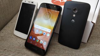 Moto E5 Play flanked by a first-generation Moto G on each side