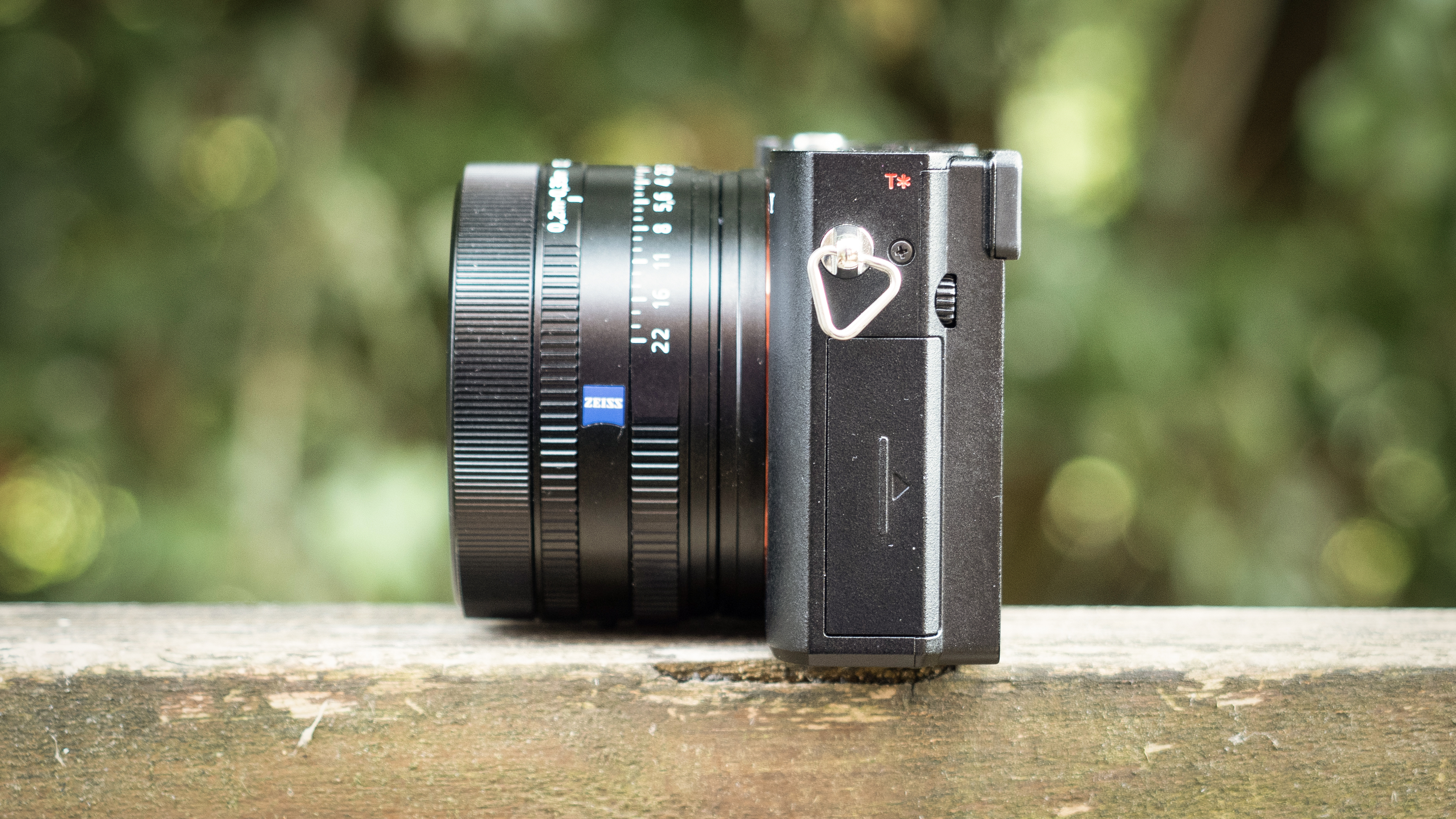 Sony RX1R III on a wooden surface in a woodland environment
