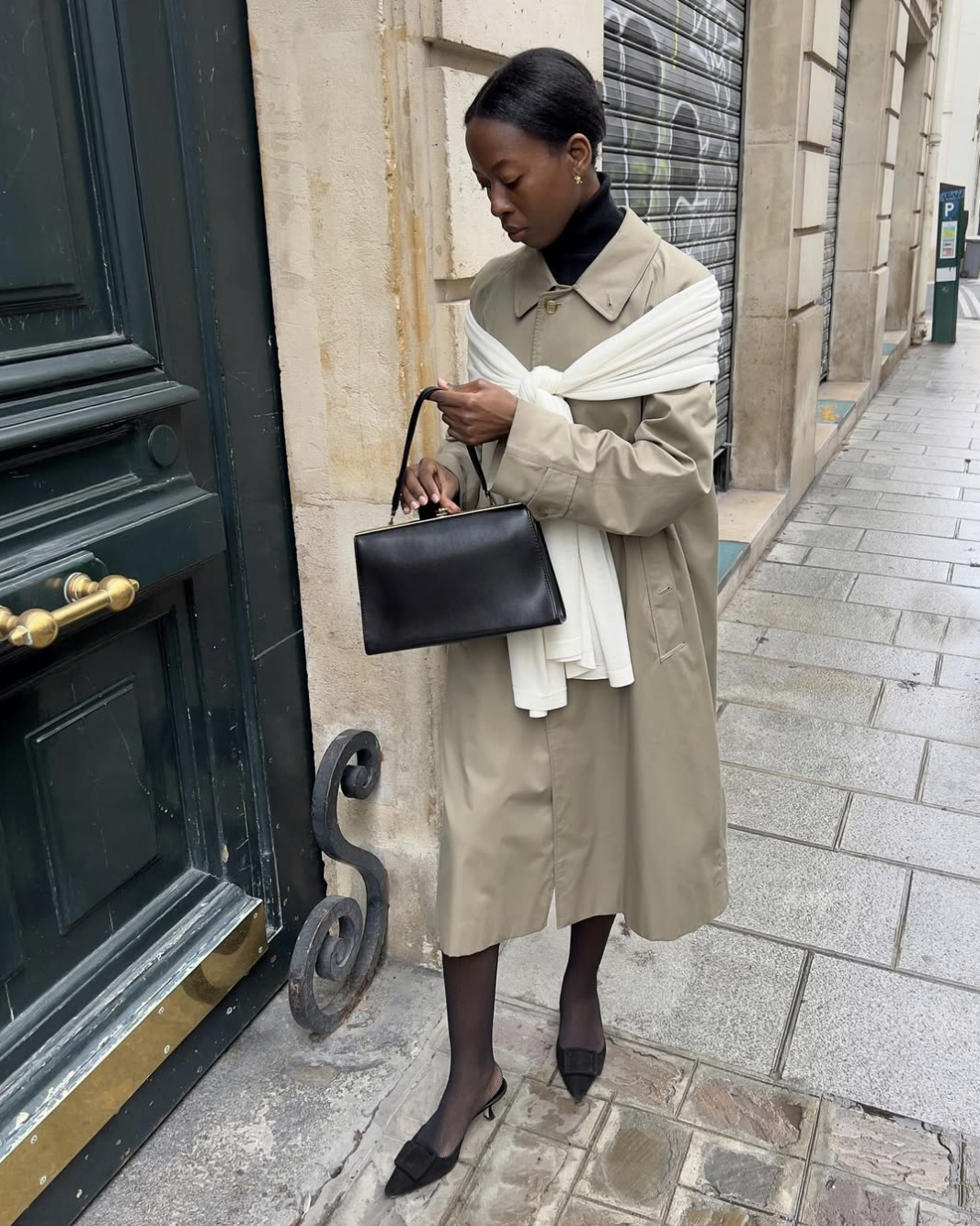 woman wearing a trench coat holding a handbag
