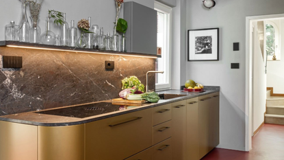 kitchen with curved gold cabinetry and black marble backsplash 