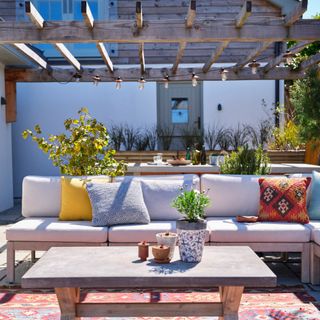 Timber pergola with garden furniture and accessories underneath it