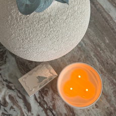 A flatlay with a lit candle and matches