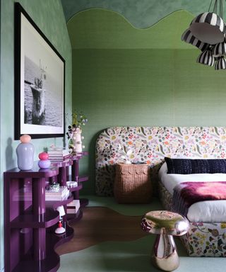 bedroom with green walls, floral patterned headboard and purple shelf unit