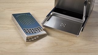 Rancilio Silvia in Stainless steel on a wooden worktop with a blue wall in the background.