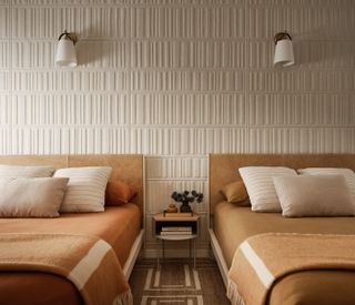 a twin guest room with textured wallpaper