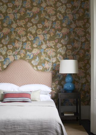 tapestry style wallpaper in bedroom, upholstered bedhead, blue lamp