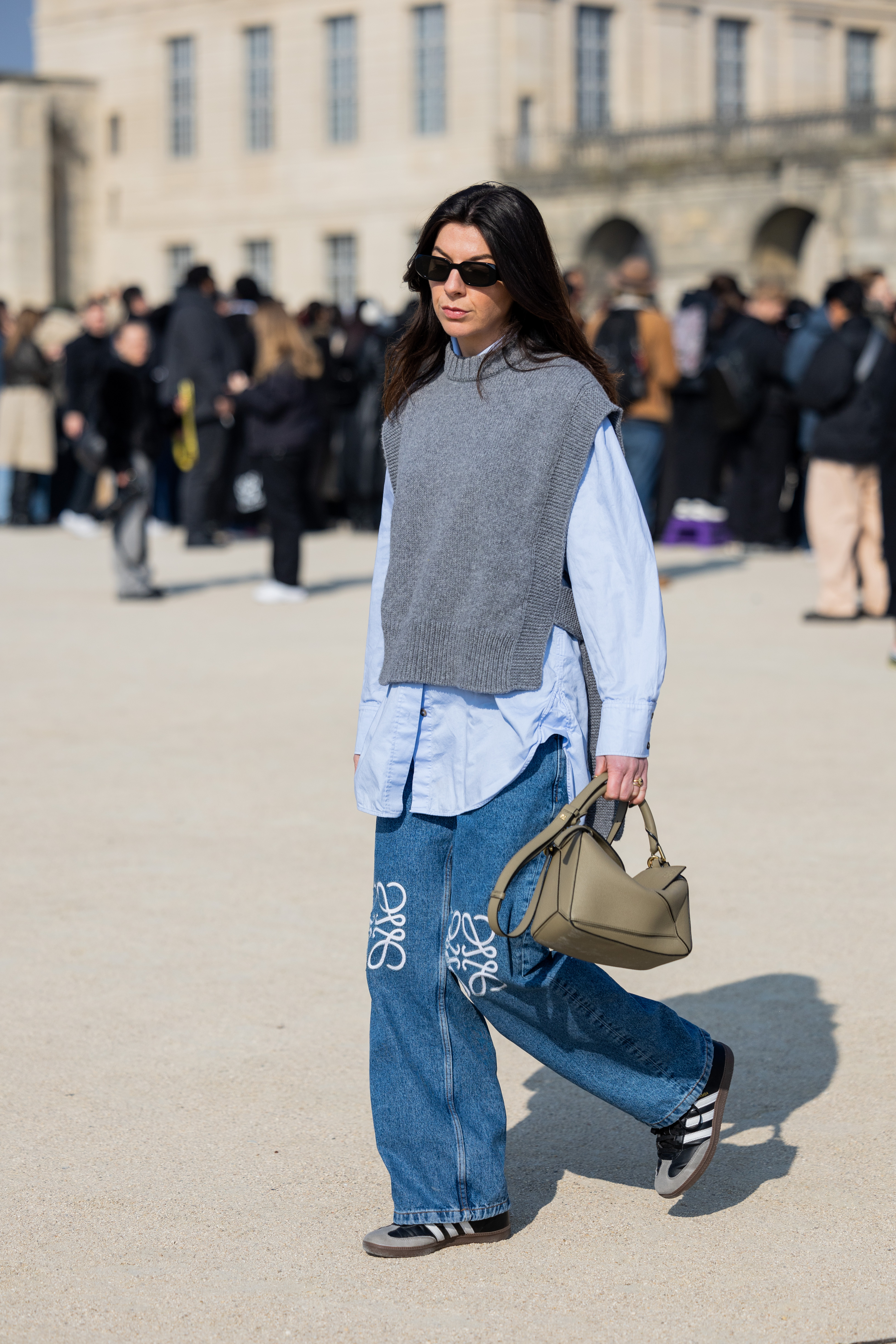 woman wearing sweater vest, button-down, jeans, and sambas