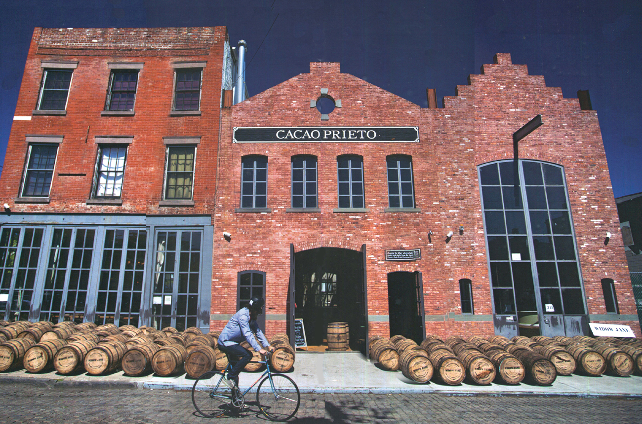 A man cycling past barrels outside a distillery