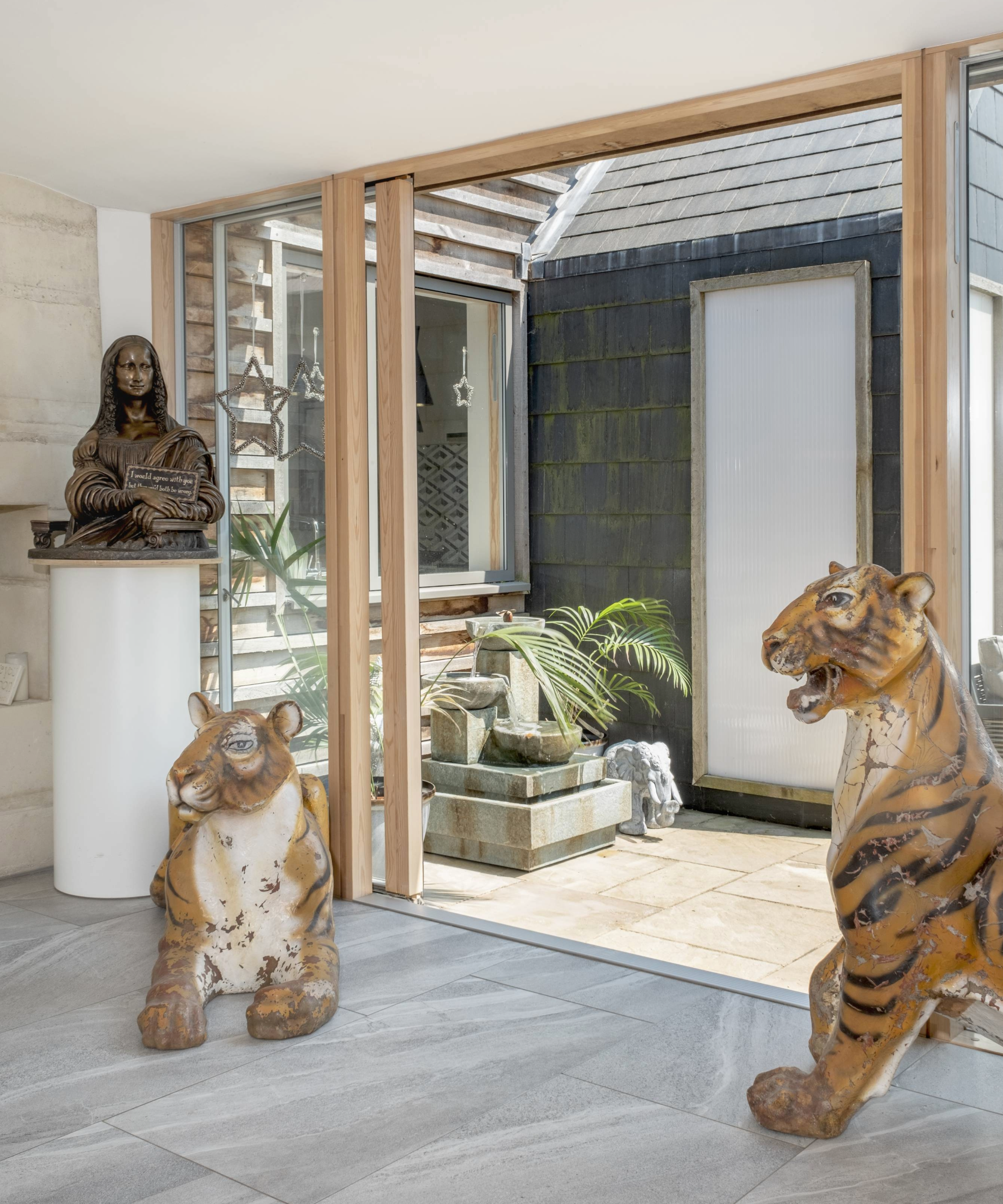 Door opening up onto the patio with tiger figures and plant