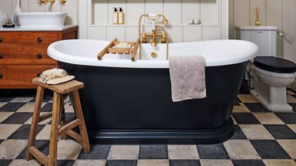 Bathroom with checkerboard flooring and black bath