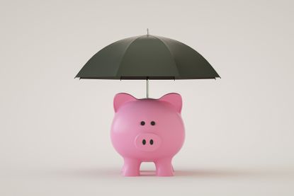 pink piggy bank with a black umbrella over it