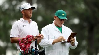 Talor Gooch consults with his caddie at The Masters
