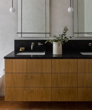 natural wood vanity in bathroom with black marble backsplash