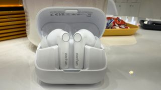 the earfun air pro 4+ earbuds in white showing the charging case, angled fit, and silicone ear tips