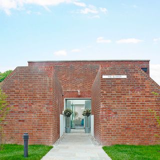 brick wall with green lawn blue sky