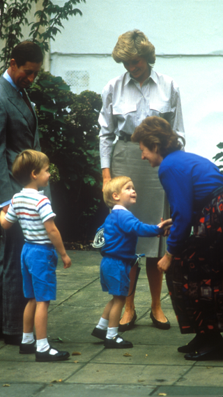 Prince Harry meets headmistress Jane Mynors on his first day at nursery school, watched by his parents Charles, Prince of Wales, and Diana, Princess of Wales, and his older brother Prince William, Notting Hill, London, 16th September 1987