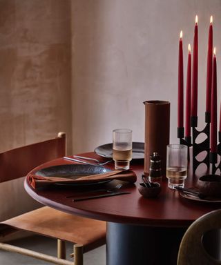 Retro style objects, candlesticks and lit candles and brown pottery plates and geometric shapes