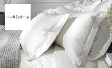 Soak and sleep logo placed over an image of a bed with white sheets