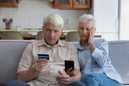 couple on the phone holding a credit card