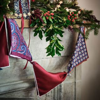 Scarf garland in purple, hung from a mantlepiece