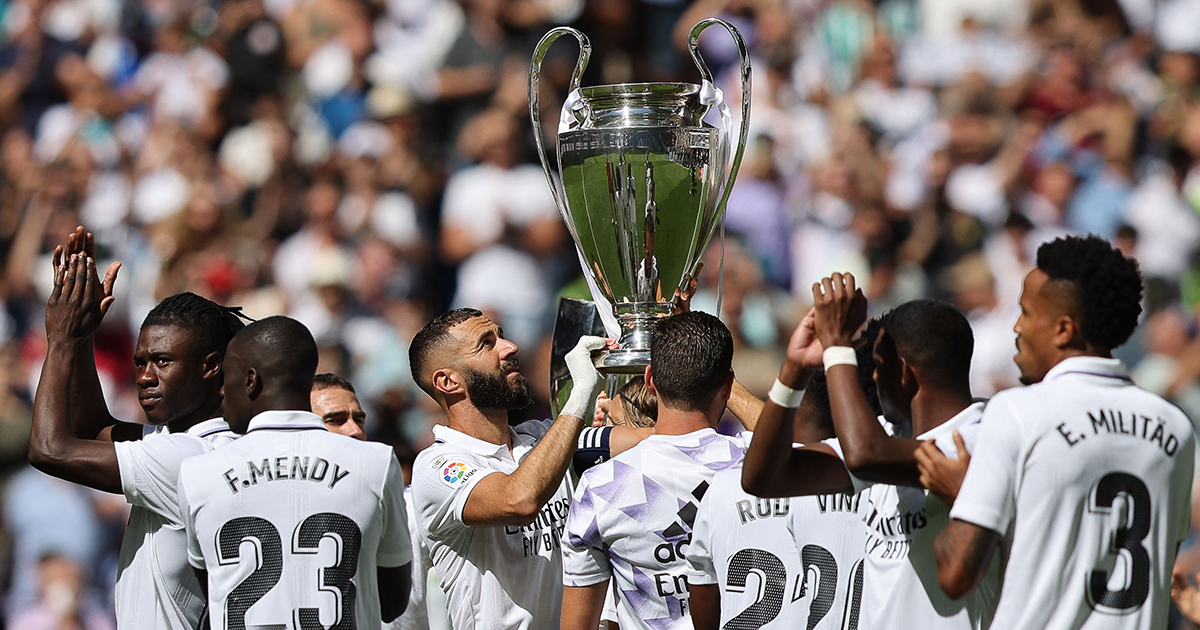 Real Madrid&#039;s French forward Karim Benzema (C) and teammates hold the European Champion Clubs&#039; Cup trophy, awarded for winning the UEFA Champions League, on the pitch before the start of the Spanish league football match between Real Madrid CF and Real Betis at the Santiago Bernabeu stadium in Madrid on September 3, 2022.
