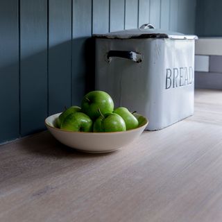 grey wall with fruit bowl and wooden worktop