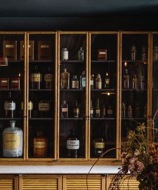 kitchen storage with haberdashery style cabinet with spices, jars and authentic pots, marble countertop, fluted wood cabinets, deVOL