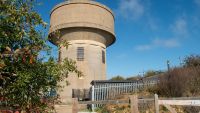 A tall, cylindrical concrete water tower