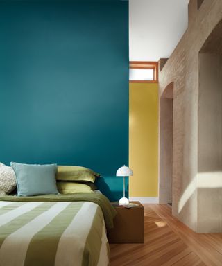 colors that go with teal, teal bedroom with yellow wall behind, green and white bedding, mid toned hardwood floor
