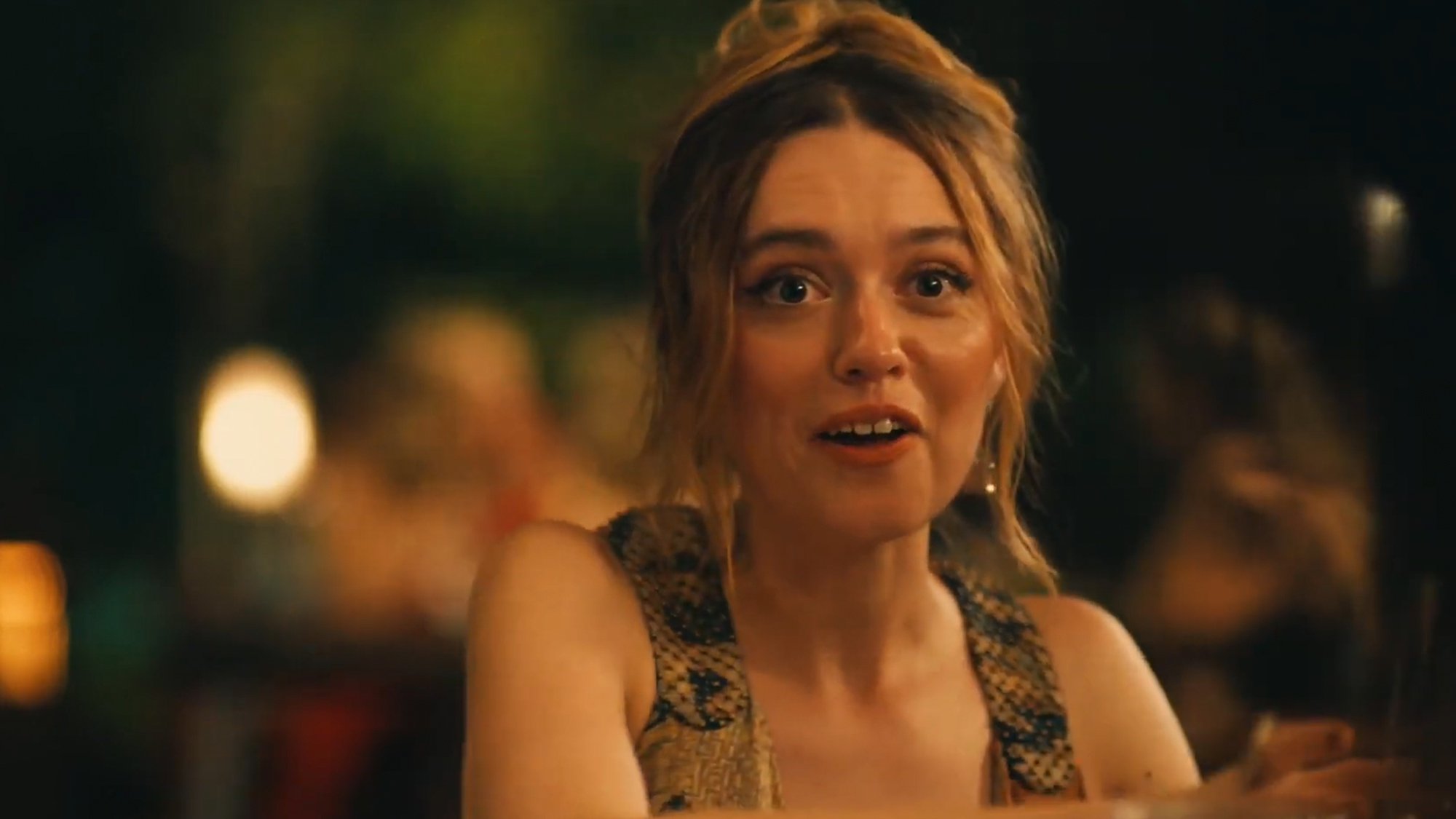 Aimee Lou Wood with wide eyes, about to laugh in The White Lotus