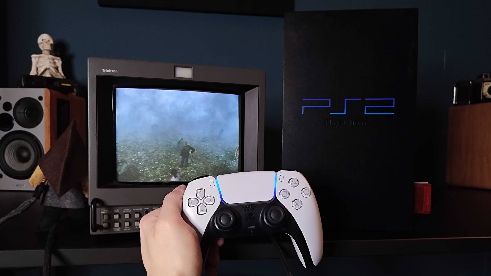 Hand holding PS5 DualSense in front of original PS2 connected to Sony PVM CRT TV on right with 8Bitdo Retro Receiver connected and Silent Hill 2 gameplay on screen.