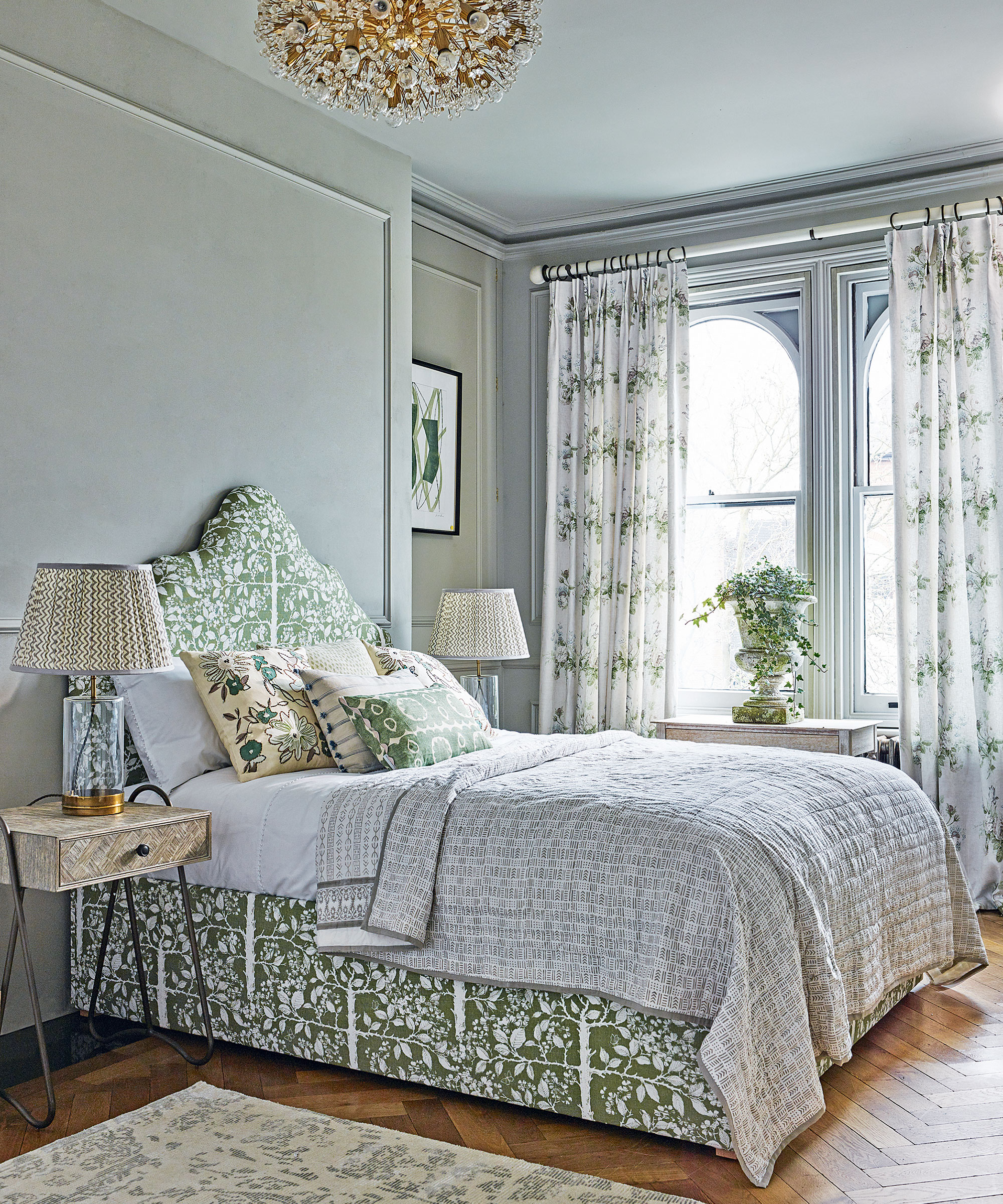 Luxury bedroom ideas with decorative bedding, ceiling light and curtains in green botanical print.