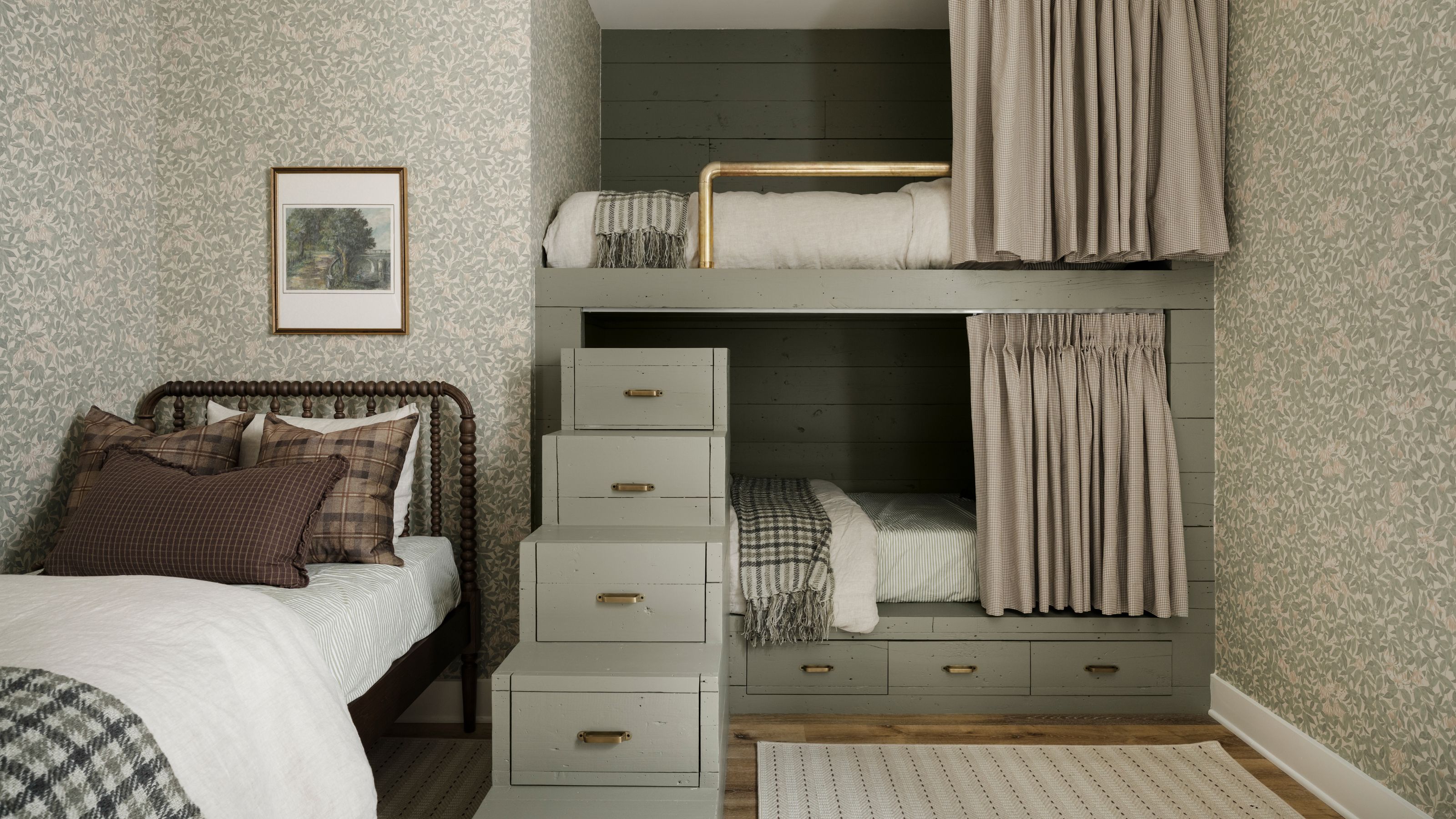 a sage green sleepover room with two built-in bunk beds, with green steps and a vintage iron single bed