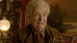 Jim Broadbent looking shocked while sitting on a couch in Paddington 2.