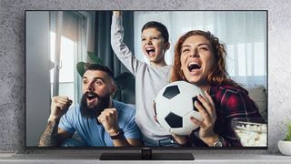 family watching television and cheering on football team