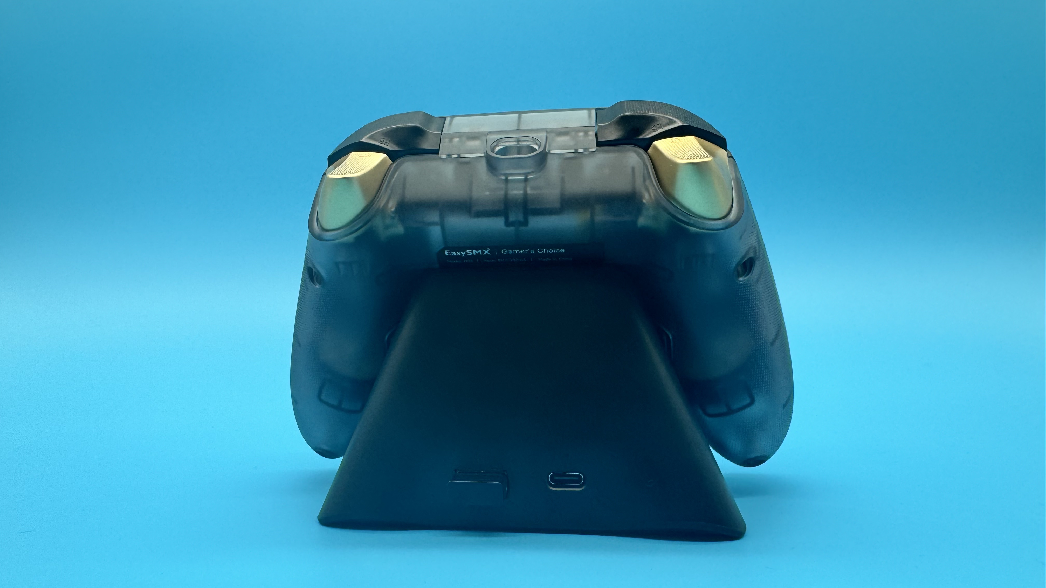 EasySMX D05 black gaming controller from behind on its charging dock, on a blue background