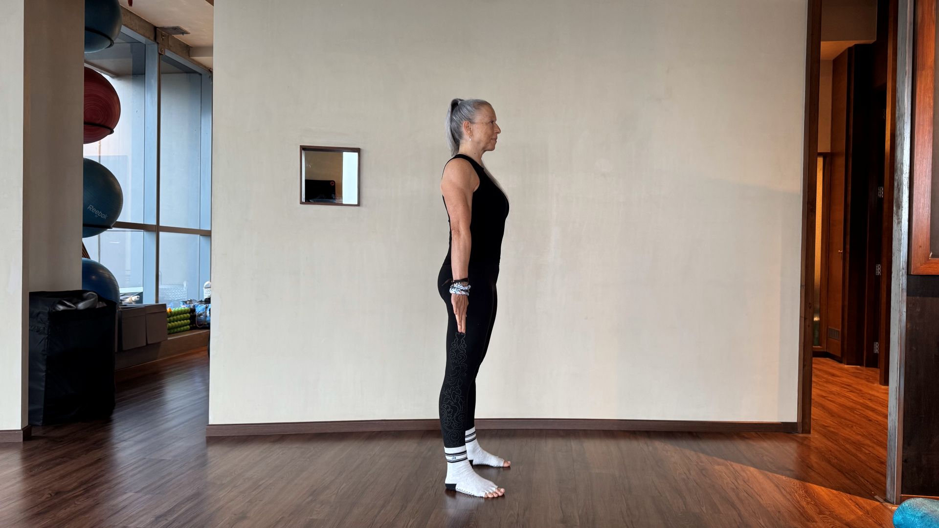 Woman demonstrates exercise in fitness studio