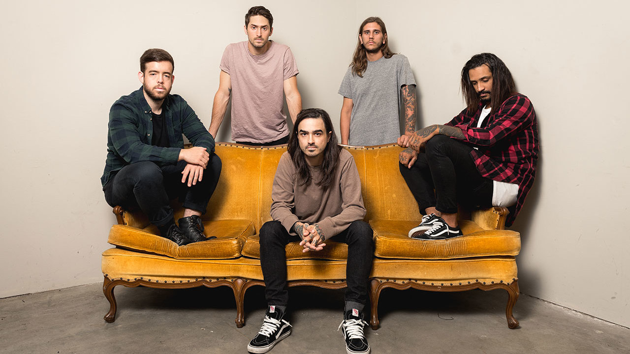 Like Moths To Flames sat on a sofa