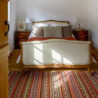 bedroom with wooden flooring and bed with bedside table