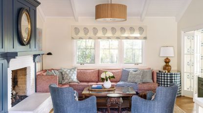 living room blue armchairs and fireplace shelving and pink sofa with patterned upholstery
