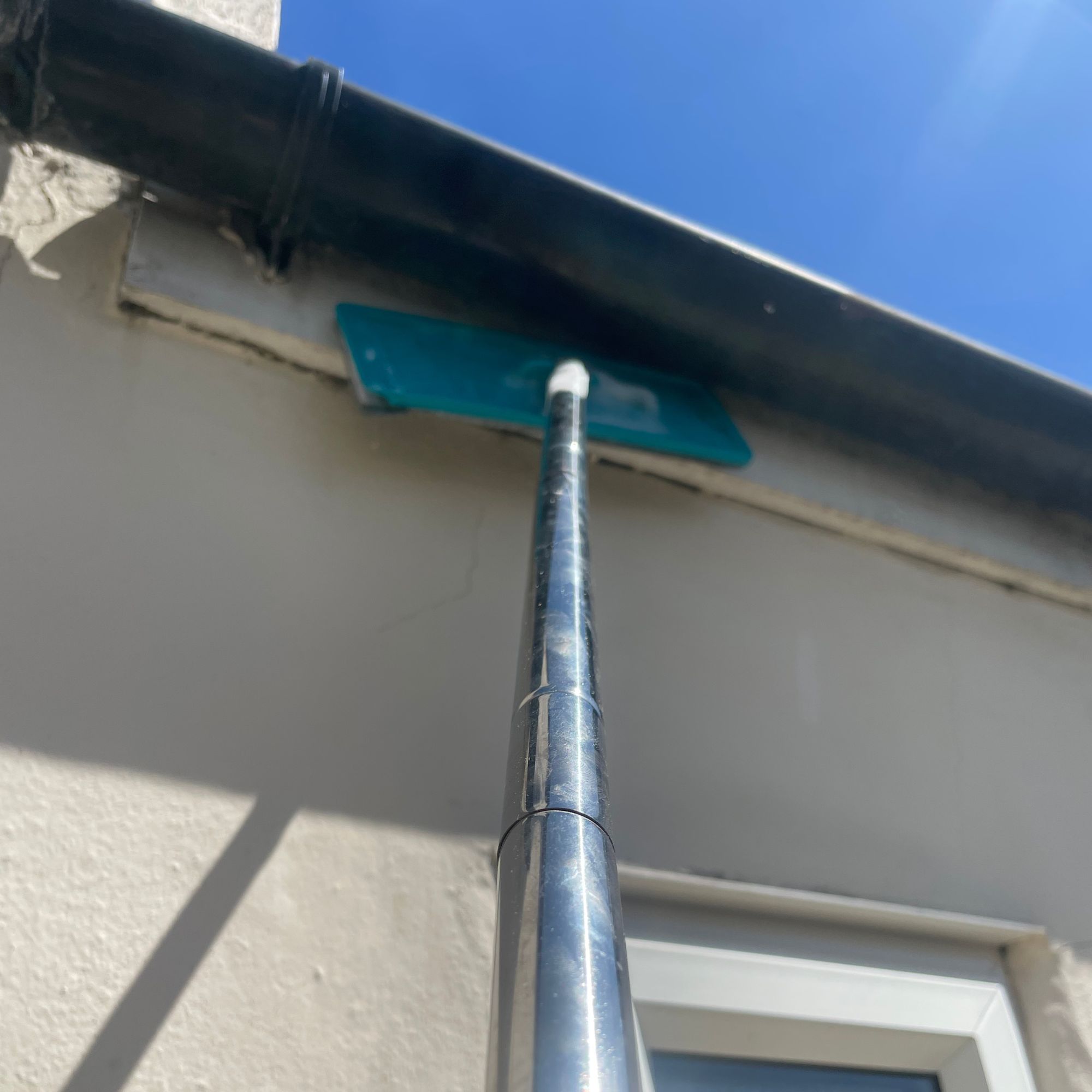 Using a mop to clean the fascias of a house