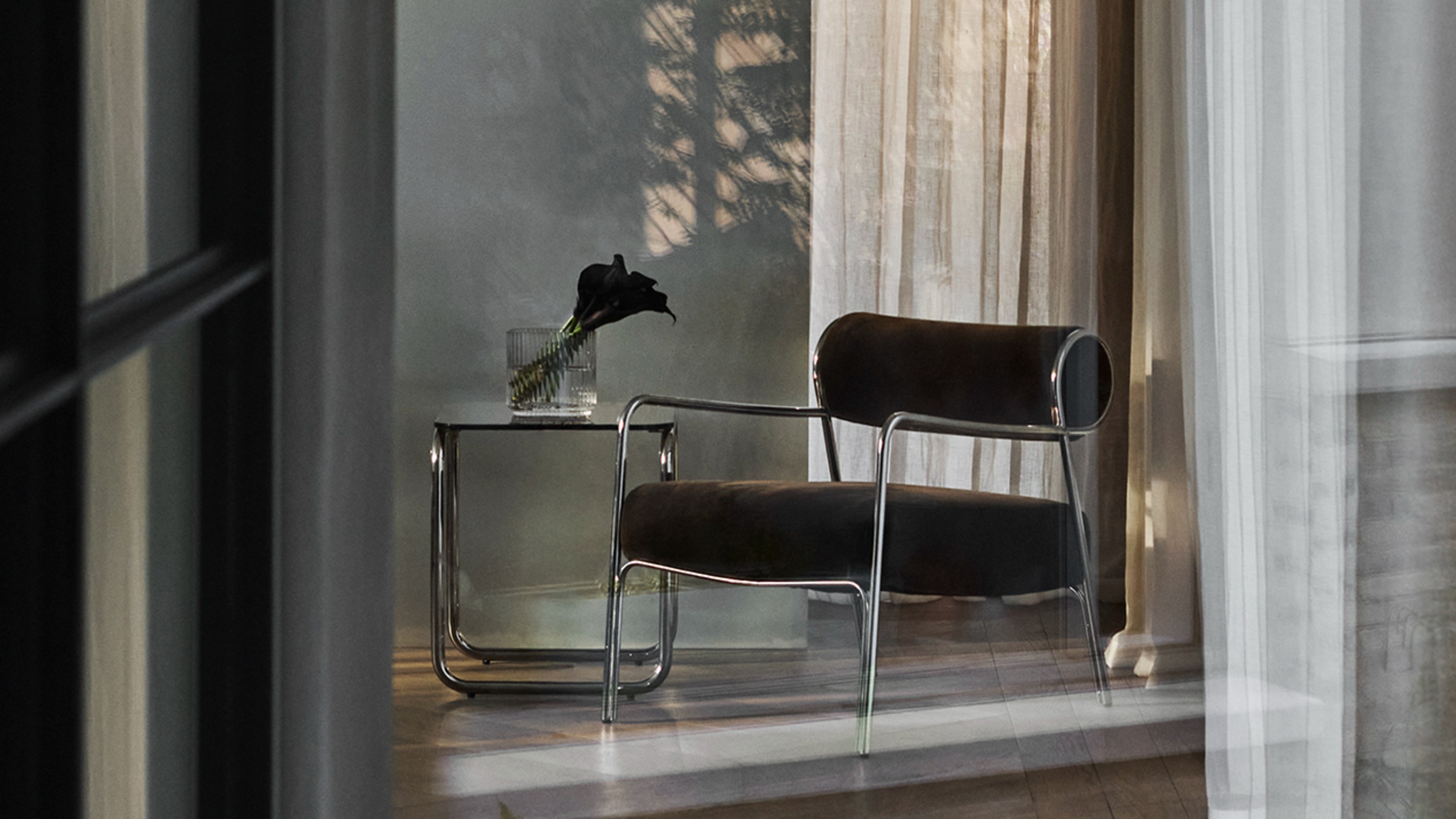 John Lewis Hoxton Armchair in hallway with a glass and chrome side table lit with dappled light