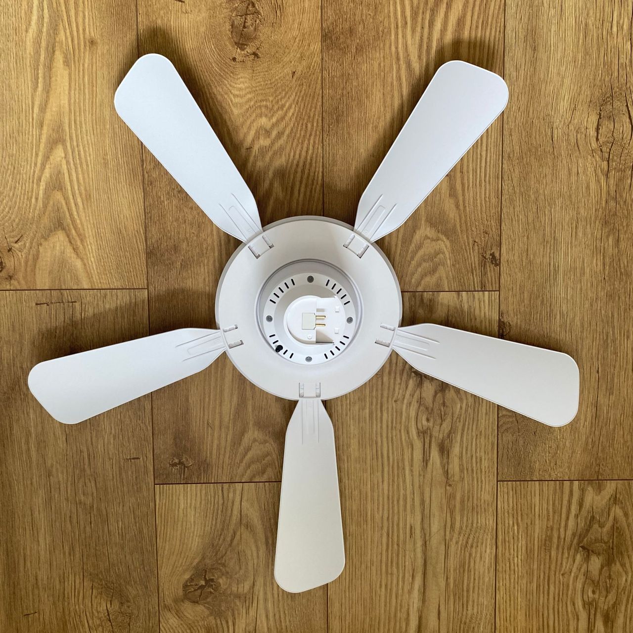 aerial shot of the fully assembled amazon ceiling fan sitting on a wood-look floor