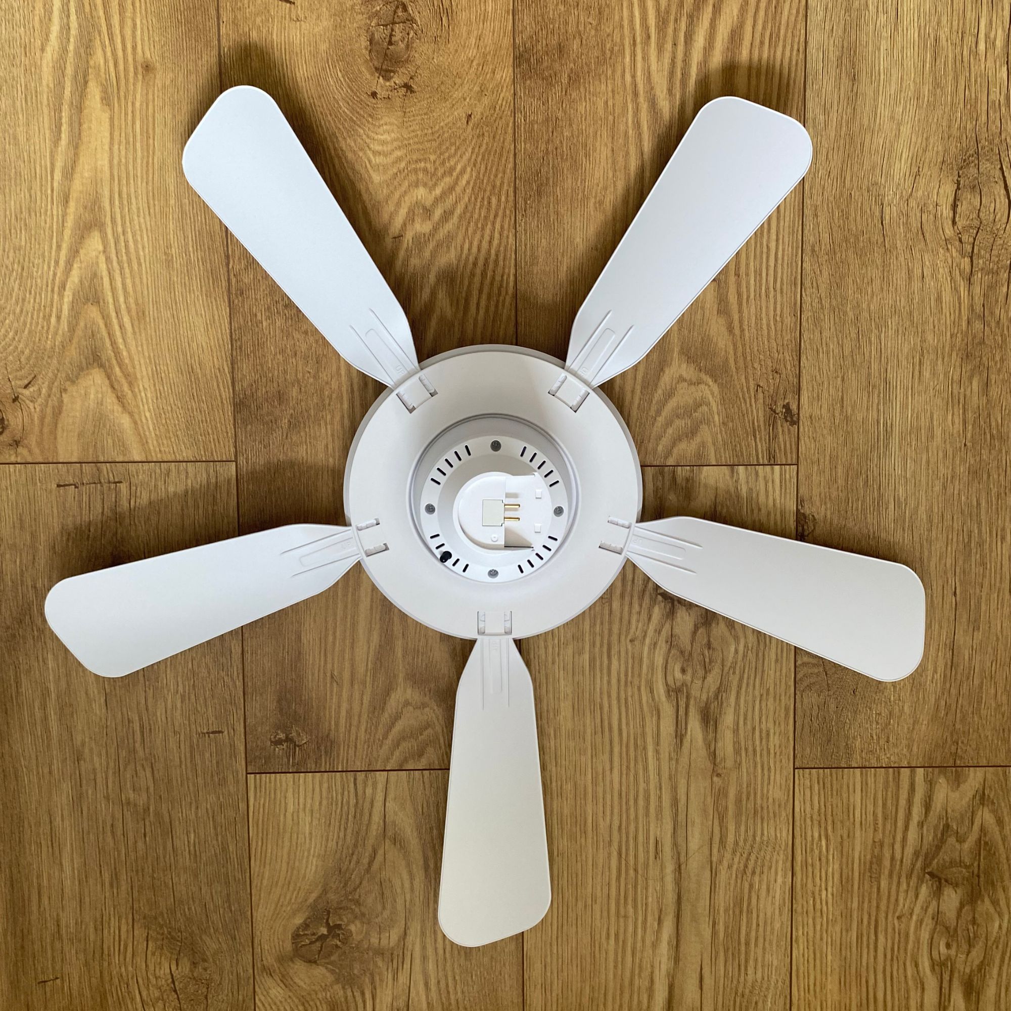 aerial shot of the fully assembled amazon ceiling fan sitting on a wood-look floor
