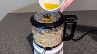 Pouring oil through drizzle funnel in lid of KitchenAid Food Chopper