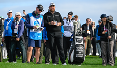 Shane Lowry chats to his caddie at the 18th hole