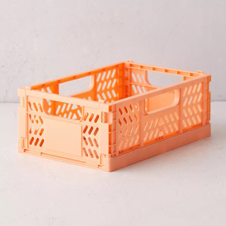 A peach orange plastic storage crate