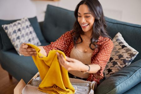 A happy women receiving second hand clothing.