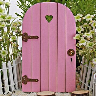 pink wooden door and white fence on both side